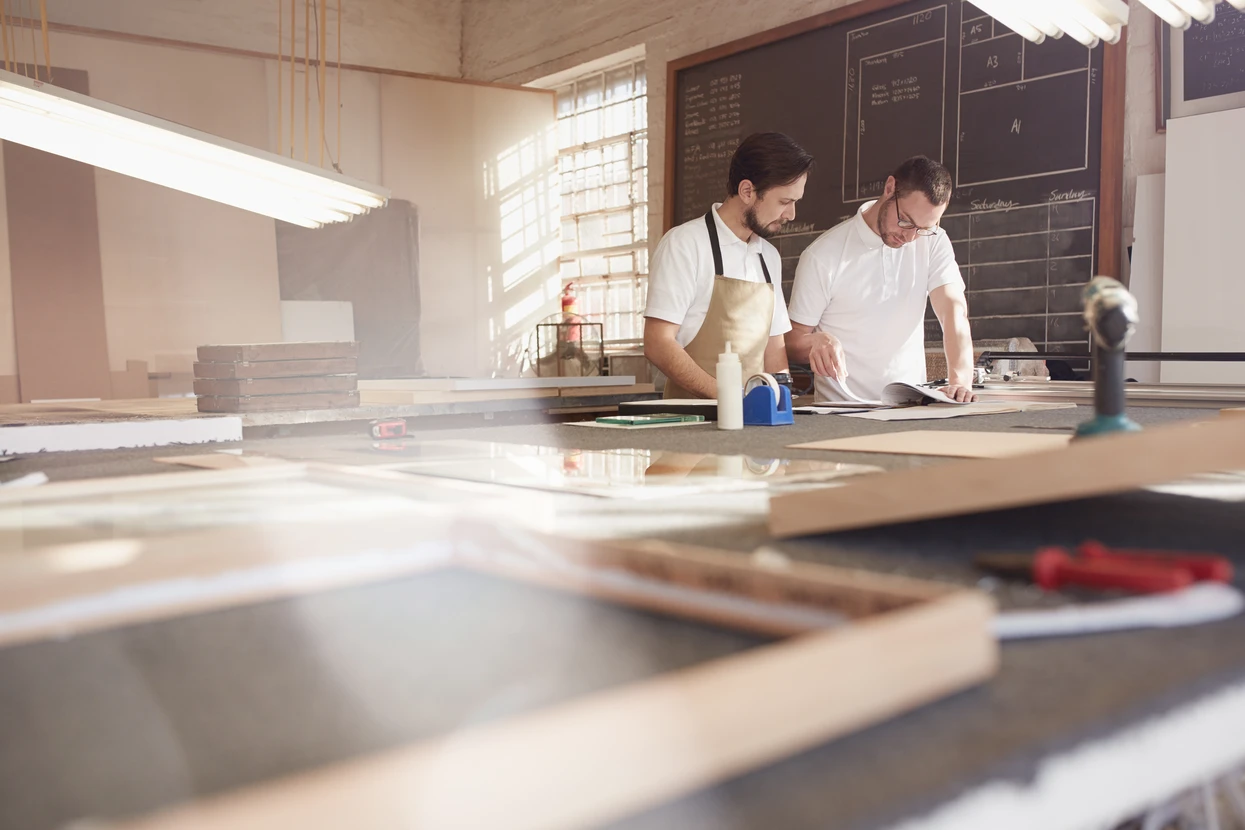 Deux commerçants travaillant sur les conceptions de cadres dans leur atelier