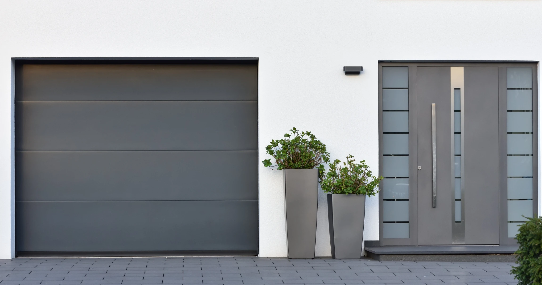 Façade moderne d'entrée résidentielle avec porte d'entrée contemporaine et garage fermé