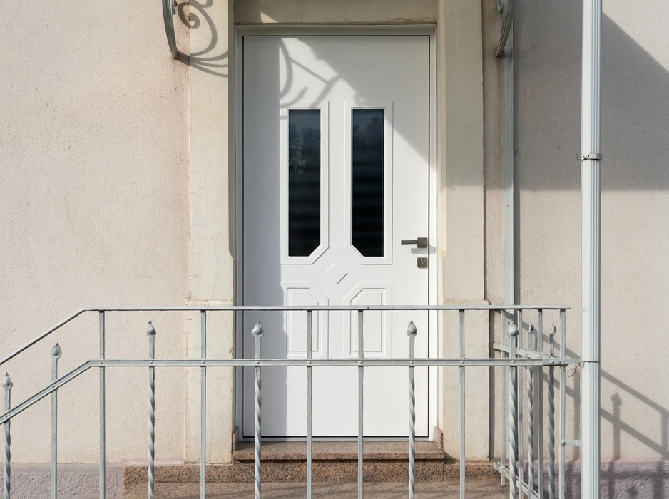 Entrée d'une maison de style provençal, façade en enduit rose, porte d'entrée moderne gris anthracite avec vitrage dépoli intégré, encadrement en pierre naturelle