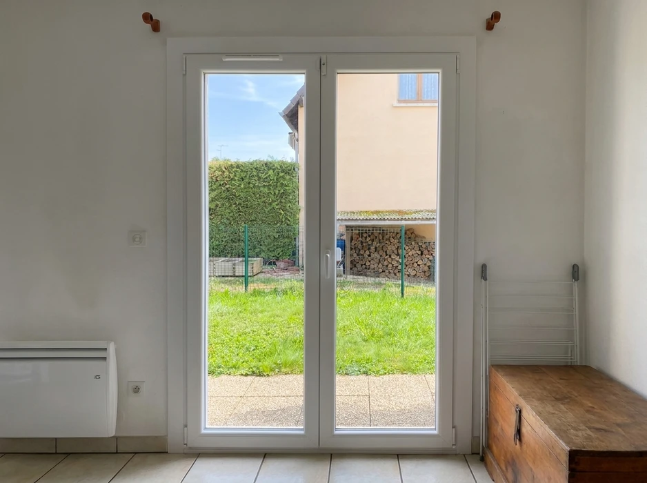 Façade extérieure en parpaings d'un bâtiment semi-abandonné avec végétation envahissante