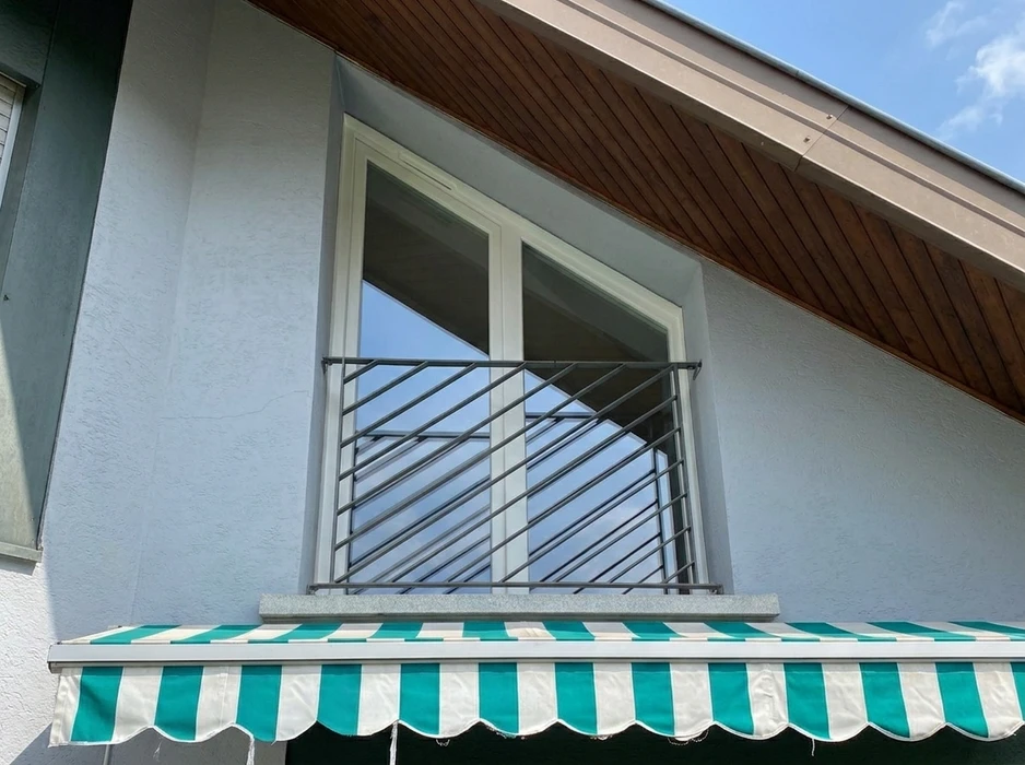 Façade extérieure en parpaings d'un bâtiment semi-abandonné avec végétation envahissante