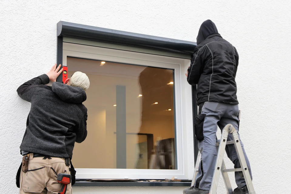 Homme en chemise à carreaux effectuant une installation ou réparation d'équipement technique dans un environnement intérieur professionnel