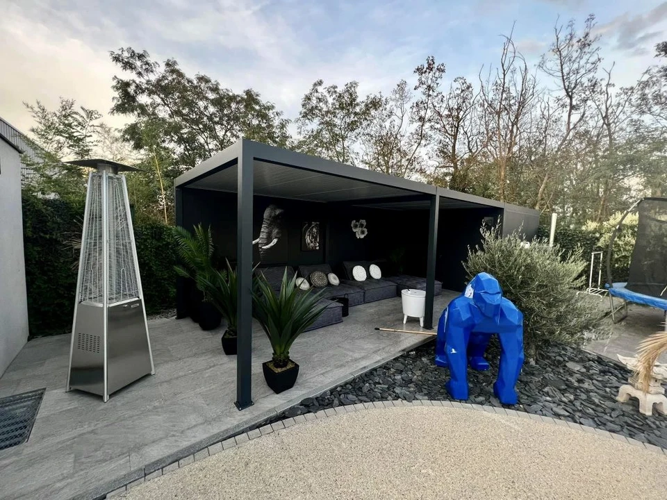 Terrasse extérieure résidentielle moderne avec pergola métallique à structure aluminium gris anthracite et couverture polycarbonate translucide